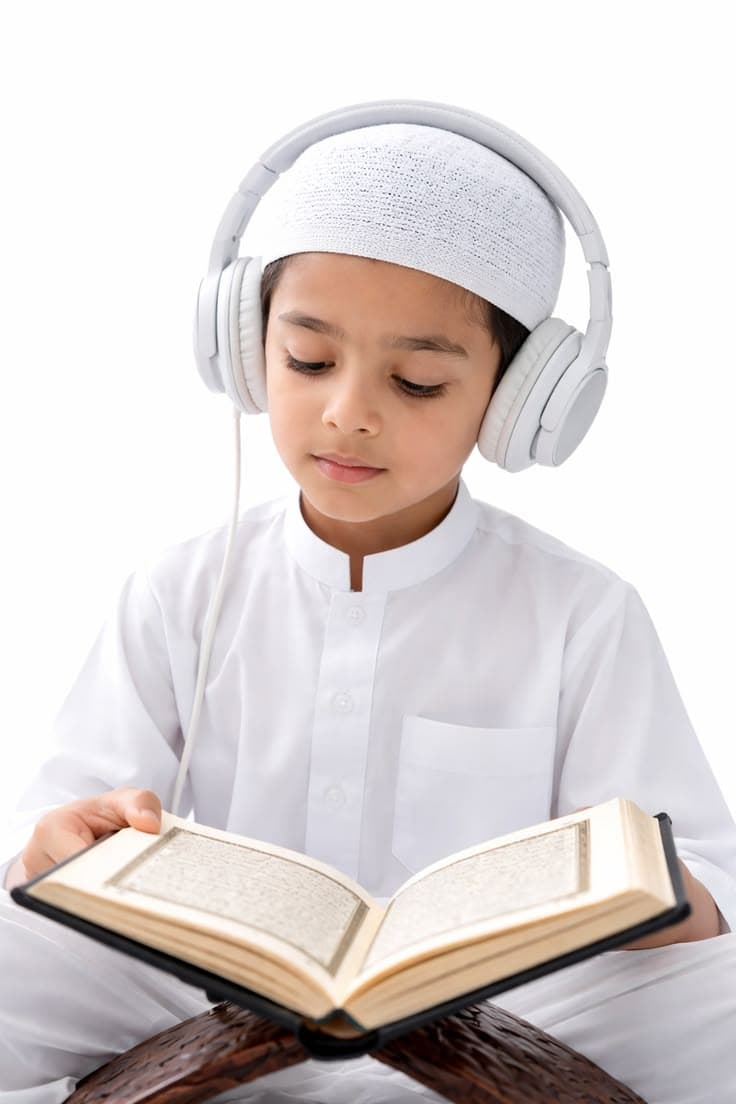 Child listening to Quran recitation while reading along